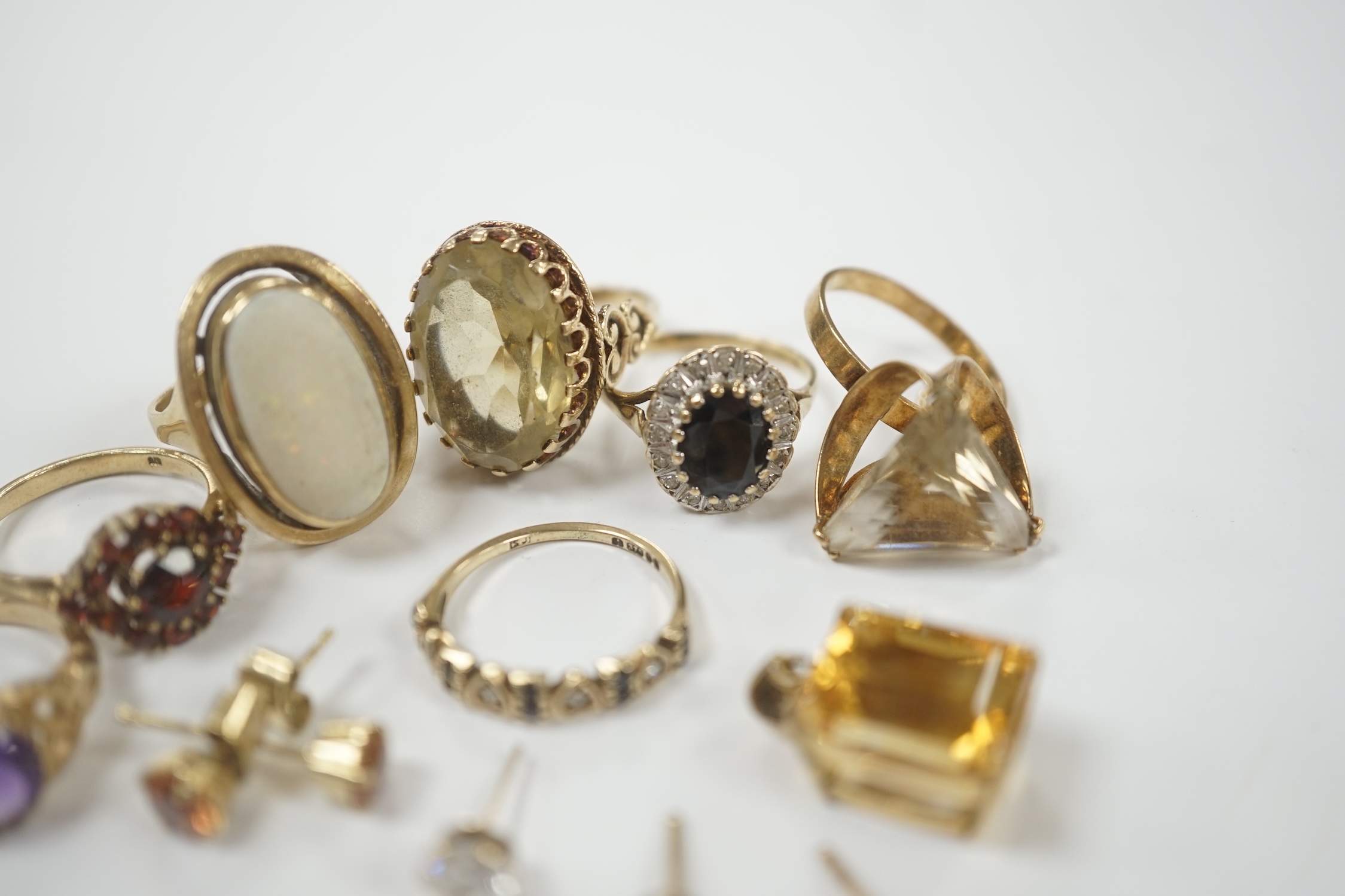 Seven assorted modern 9ct and gem set rings, including garnet cluster, white opal and amethyst, gross weight 26.2 grams, together with a pendant and assorted ear studs.